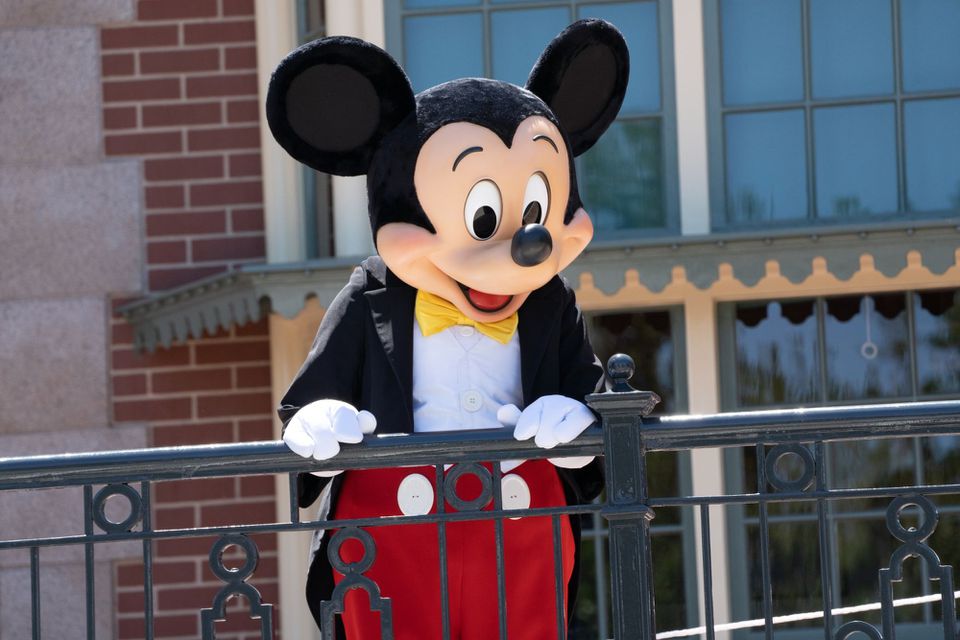 A performer dressed as Mickey Mouse entertains guests during the reopening of the Disneyland theme park in Anaheim, California on April 30, 2021.